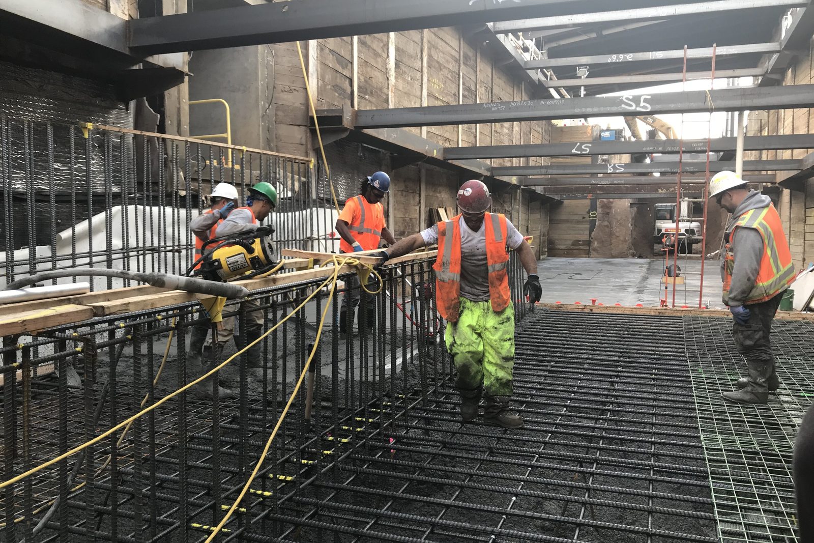 Worker in hard hat and hi-vis among rebar
